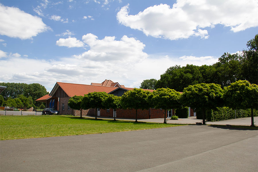 Gebäude mit vorgarten Hier wird das Gebäude mit der Allee und dem vorgarten in den Sommermonaten gezeigt.